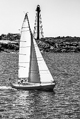 Sailboat Passes By Marblehead Light Over Rocky Shoreline -BW